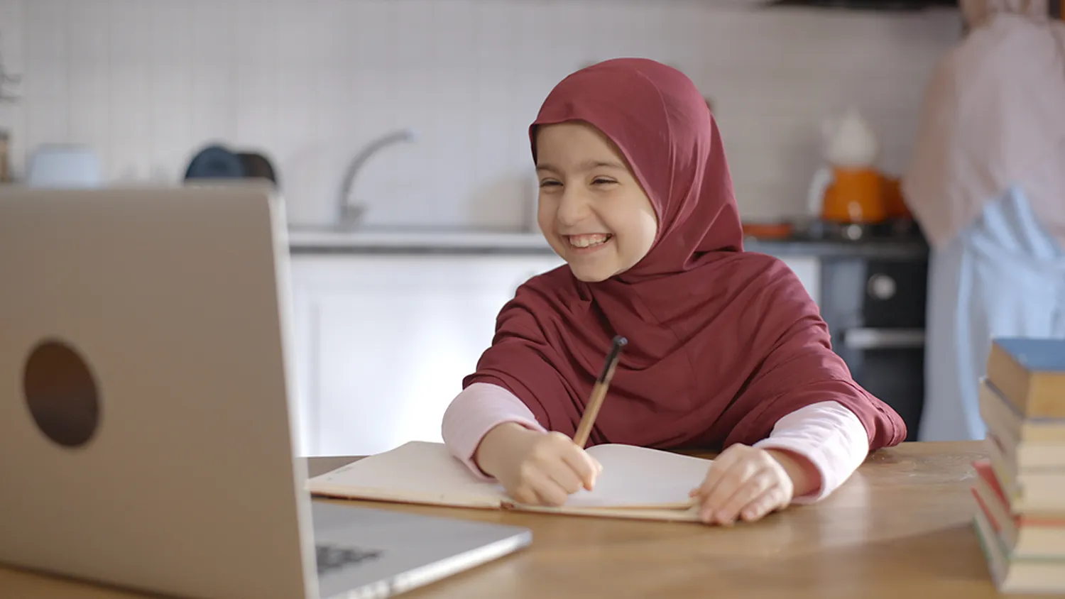 Happy young Muslim girl smiling during interactive online Quran lesson with Quran Janan Academy